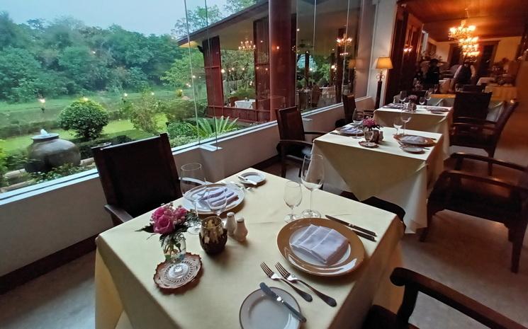 Vue de la salle de restaurant et du jardin en bord de riviere au Crystal a Chiang Mai