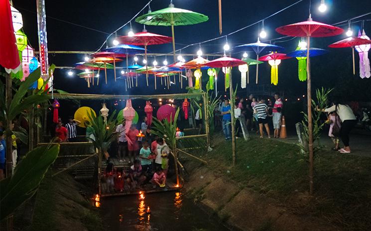 Des villageois sont reunis autour d'un canal pour celebrer Loy Krathong dans le nord de la Thailande
