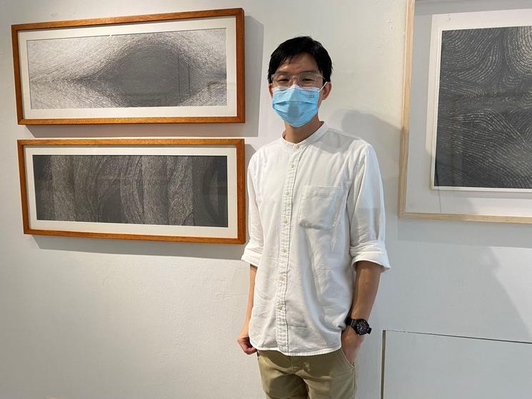 galeriste devant son exposition