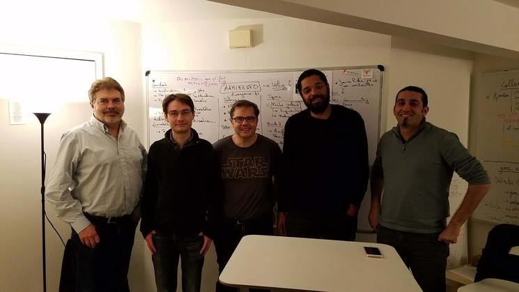 Un groupe de personne devant un tableau blanc avec des formules mathematqiues