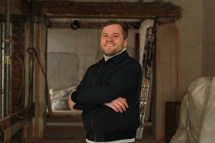 Pierre Martin croisant les bras et souriant dans le local de son futur magasin à Munich