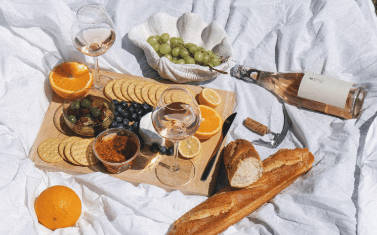 pique-nique sur une nappe blanche avec vin et baguette