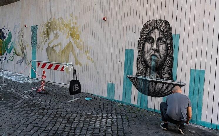 un street artist peint un murales à Rome au Palais Farnèse