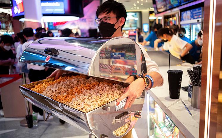 Un Thailandais porte un chauffe-plat rempli de pop-corn au cinema