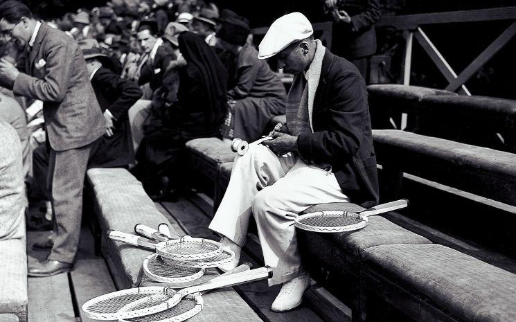 René Lacoste préparant le manche de ses raquettes en bois avec du ruban adhésif, 1927 (Crédit : (c) Presse Sports)