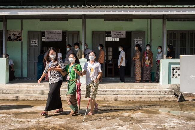 Des Birmanes sortant du bureau de vote