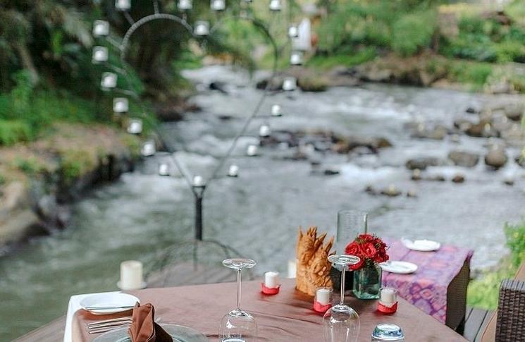 Restaurant Swept Away à Samaya Ubud à bali avec une table faisant au bord de la rivière et une strcuture en forme de cœur