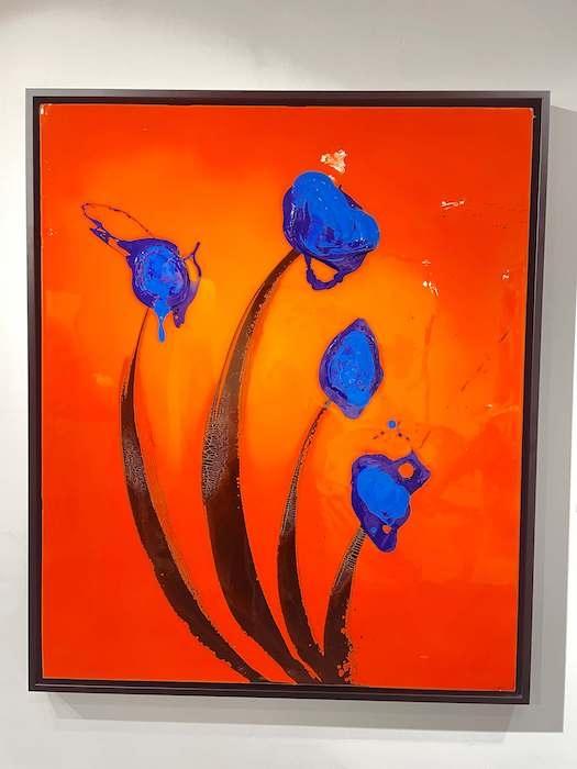 un tableau de SA Candela représentant des tulipes bleues sur fond orange