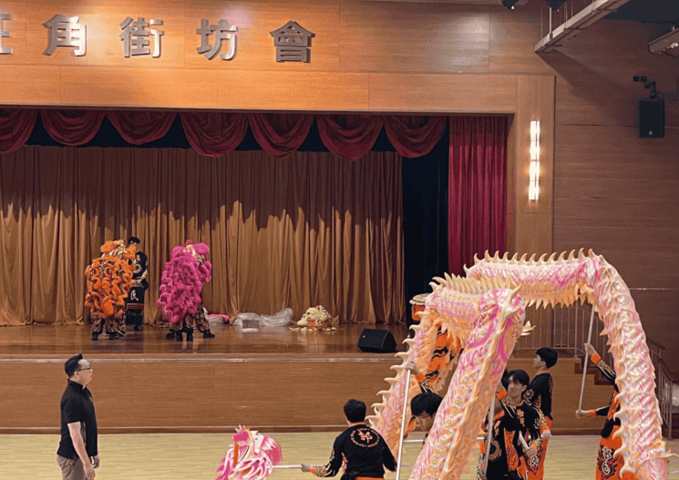 Le Maitre à la gauche de l'image supervisant une équipe masculine de danse du dragon