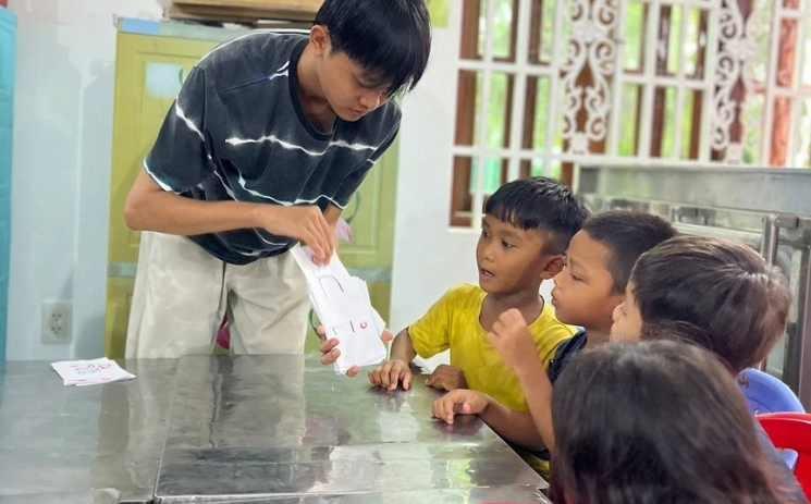 Sopha explique l’alphabet khmer au enfants du Centre EKL dans le cadre de ses cours de soutien scolaire