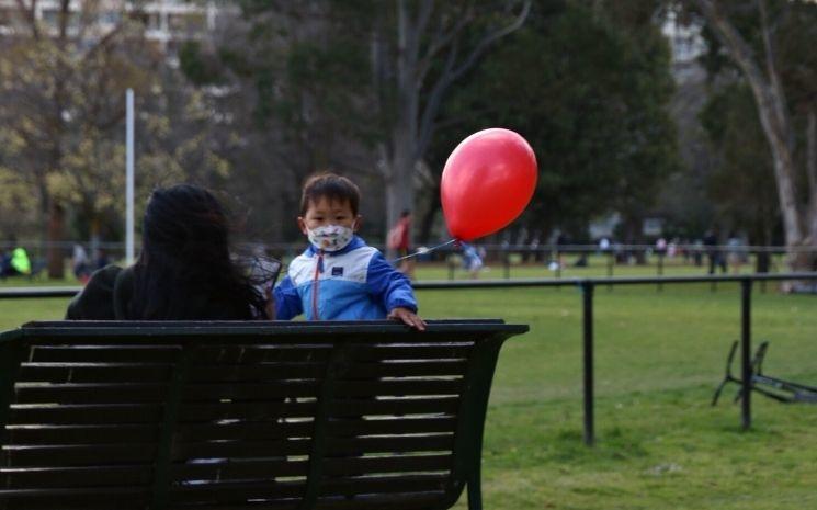 Enfant portant un masque dans un parc de Melbourne