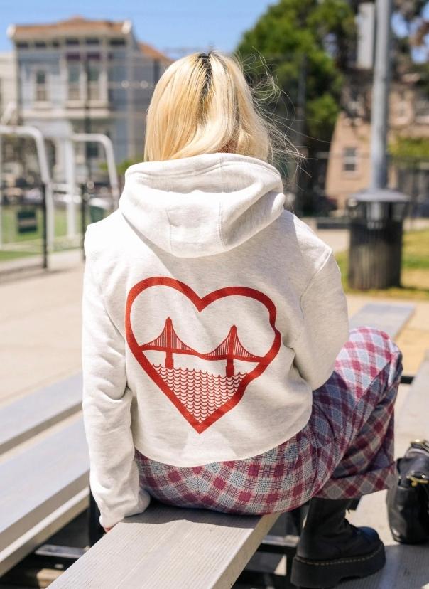 Fille sur un banc avec un sweatshirt I Love SF