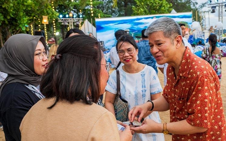 Des participants au salon du tourisme en Thailande TTM+ 2024 discutent sur la plage lors du cocktail de lancement