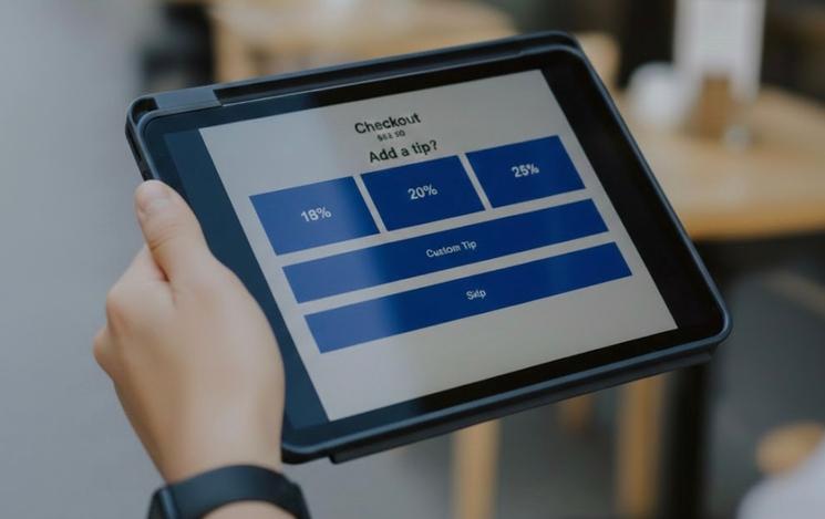 Un tablette numerique au moment du checkout pour la demande de pourboire.