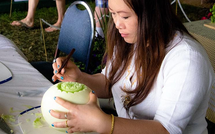 Une Thailandaise sculpte un fruit lors d'une foire
