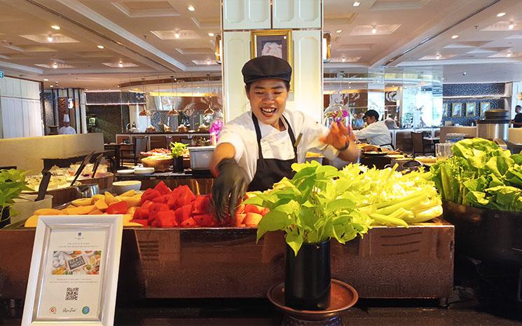 Une employee de l'hotel Athene Bangkok sert des jus de fruit frais au petit dejeuner