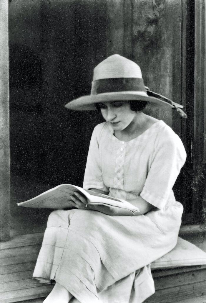 une femme des années 20, assise, lit un livre