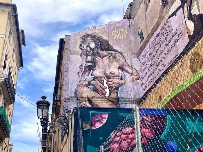 un monstre avec un masque à gaz et des seins de femme peint sur un immeuble à Valencia par ToniEspinar