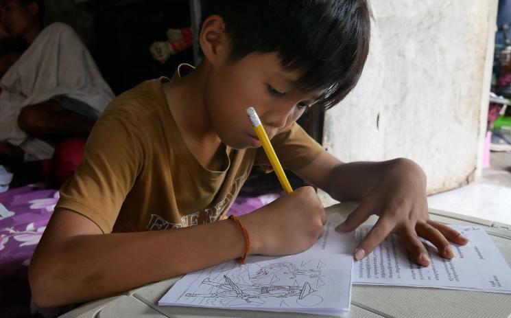 Pitch faisant ses devoirs de vacances sur une valise improvisée en table