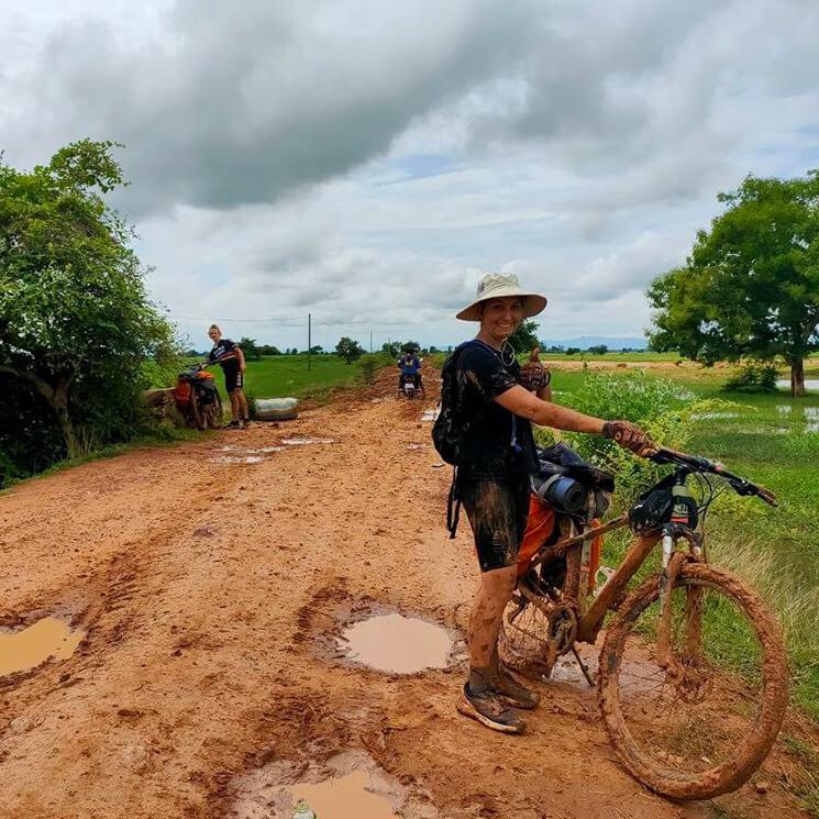Une jeune cycliste en prise avec la boue dur les pistes de battambang