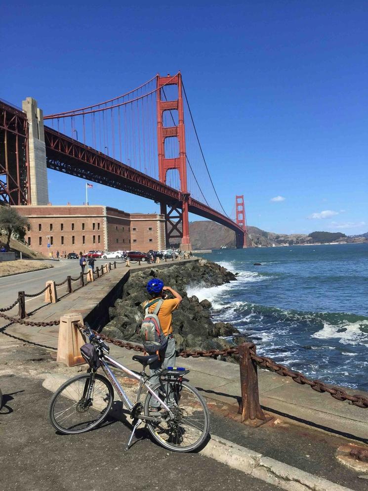 Un touriste à velo au pied du Golden Gate