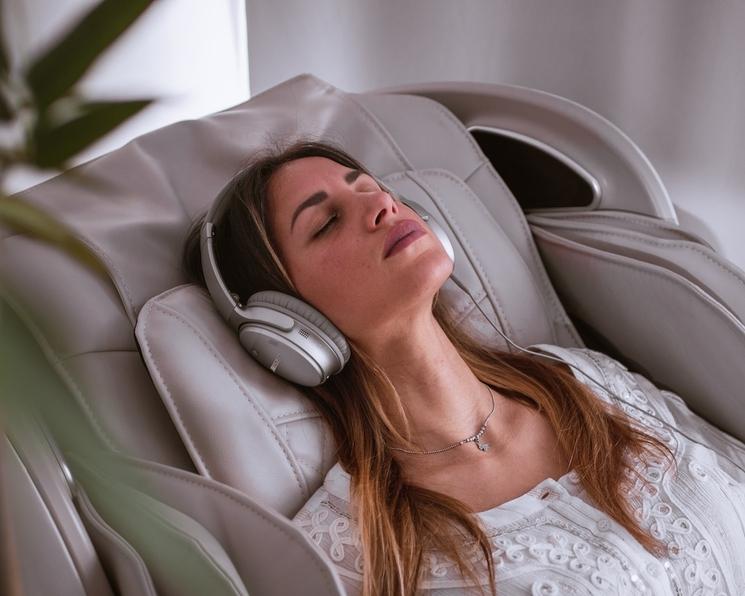 femme blonde t-shirt blanc assise qui se relaxe avec un casque