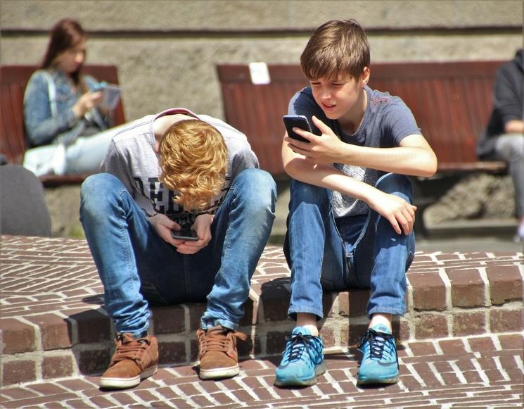 adolescents assis et sur leur téléphone
