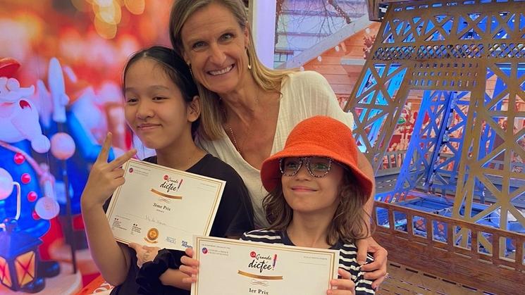 Alexandra pose avec sa maitresse après avoir reçu un diplome pour la dictée