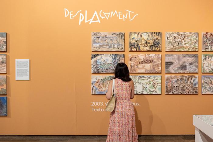 une personne en trainde regarder des illustrations de Miguel Calatayud au centre del carme de valencia