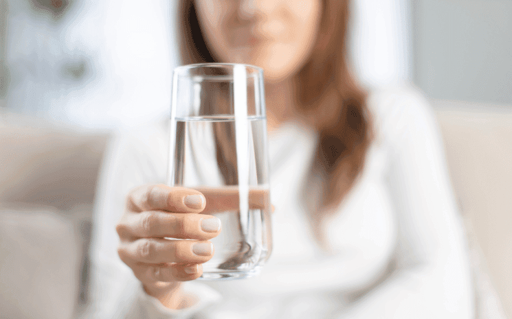 femme qui tend un verre d'eau