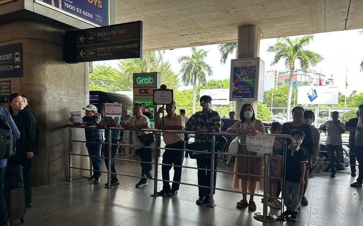 Chauffeurs de transfert privé attendants leurs clients pancartes à la main à l’Aéroport International de Tân Sơn Nhất