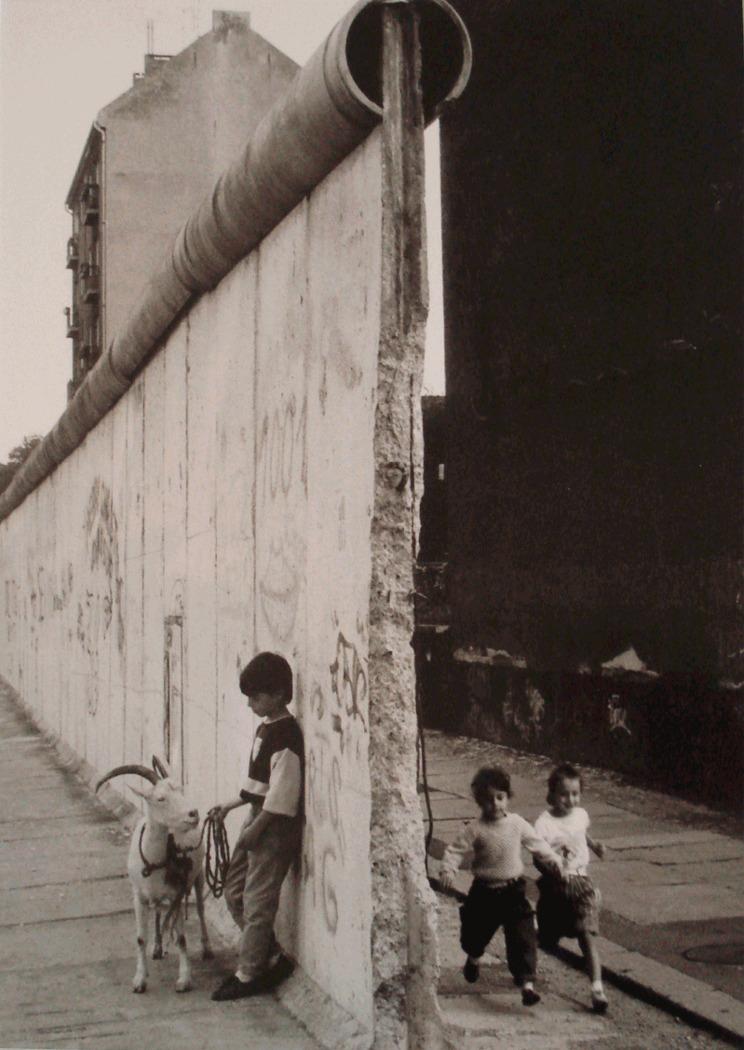 Enfants avec une chèvre devant le mure de Berlin