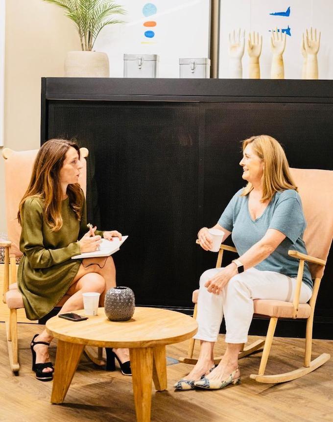 deux femmes assises parlent en souriant