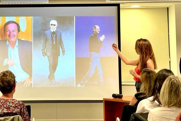 une personne parle devant un écran