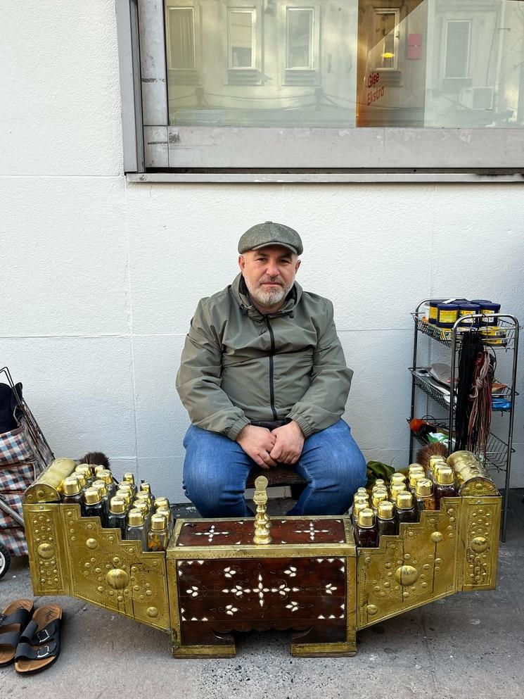 Un cireur de chaussures assis avec son matériel en laiton traditionnel dans une rue d’Istanbul