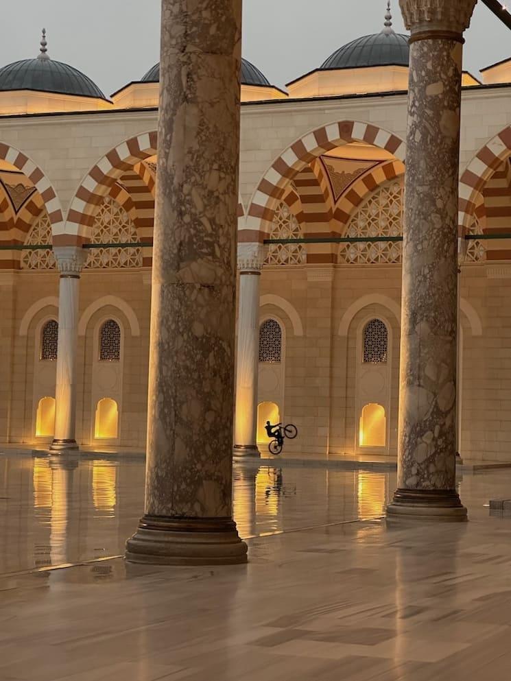 Photo gagnante 2025 du concours photo Istanbul Accueil : un cycliste dans la cour d’une mosquée.