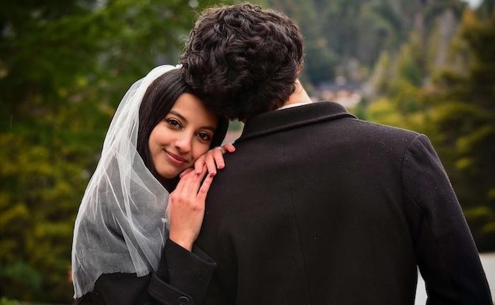 un couple mixte : homme de dos, jeune femme souriante