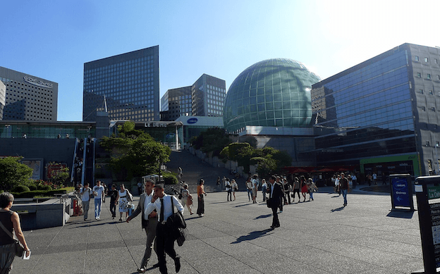 Des personnes marchent dans le quartier de la Défense à Paris.