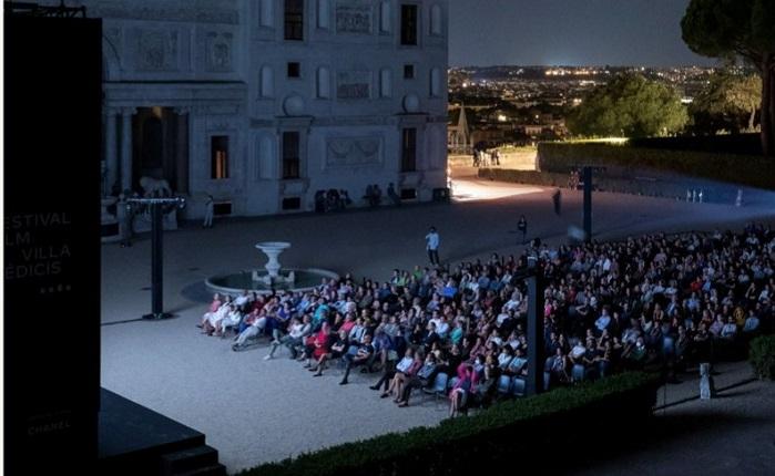 des gens regardent un film en plein air