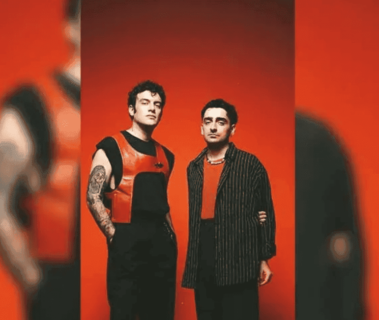 Portrait artistique du duo Dolu Kadehi Ters Tut, posant devant un arrière-plan rouge vif, promouvant leur concert de pop alternatif à Izmir en janvier 2025.