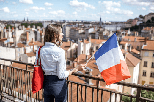 Une française tient le drapeau français en Espagne et sourit