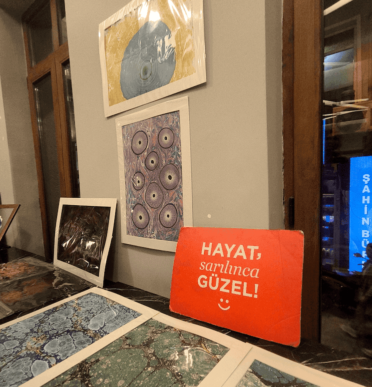 Œuvres exposées et panneau « Hayat, sarılınca güzel » lors de l’événement solidaire Ebru Life.