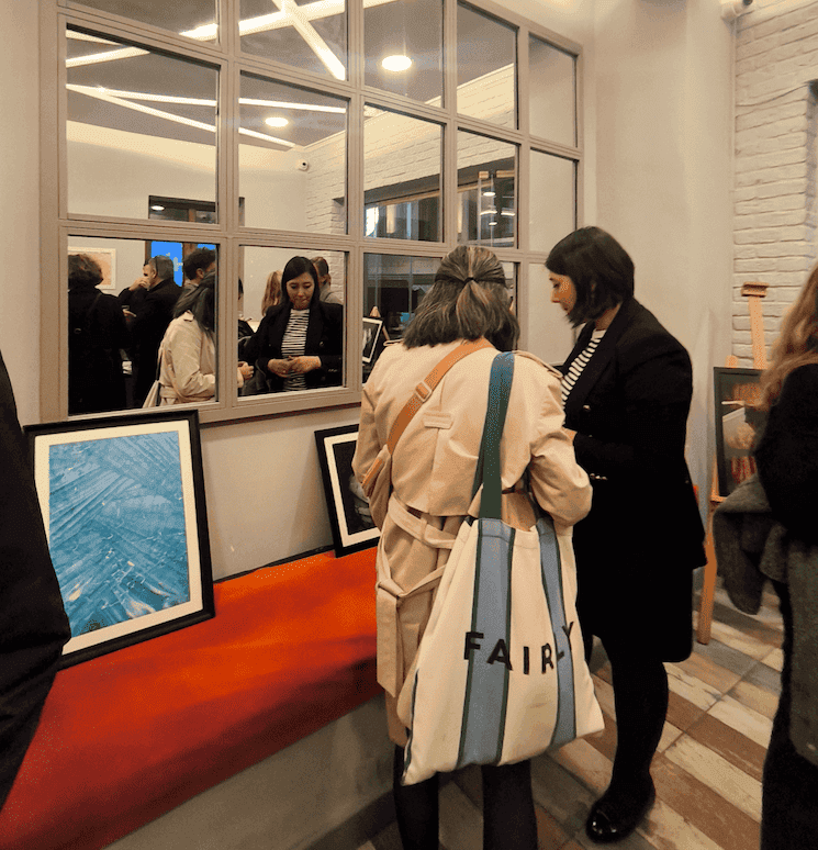Invités en échange devant les œuvres lors de l’exposition solidaire Ebru Life à Beyoğlu.