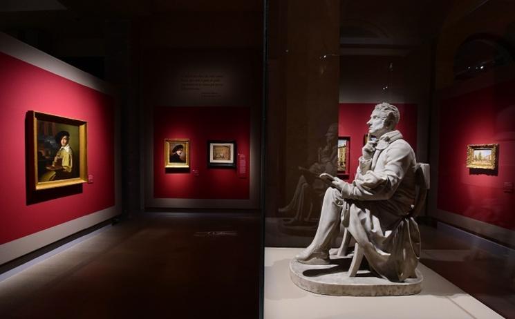 exposition statue devant des tableaux