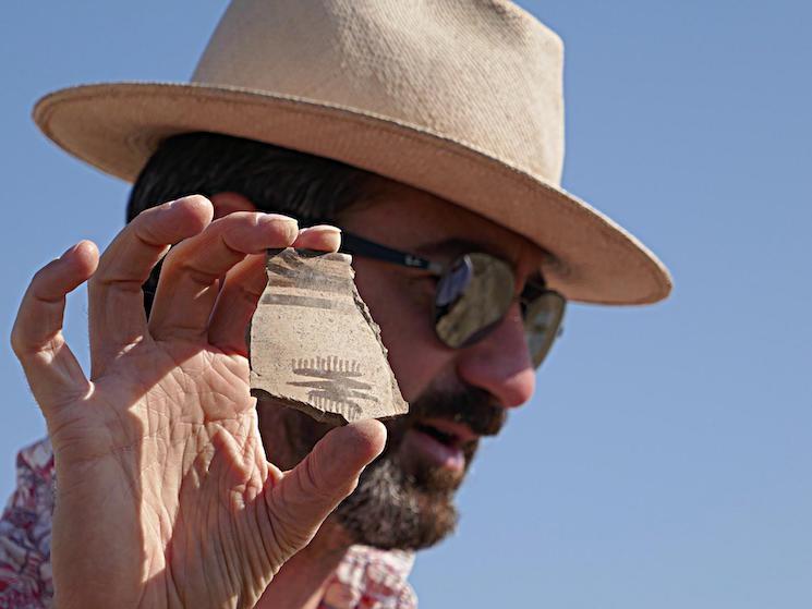 François Desset, l'archéologue qui a déchiffré l'élamite linéaire à Téhéran, en train de tenir un objet durant des fouilles