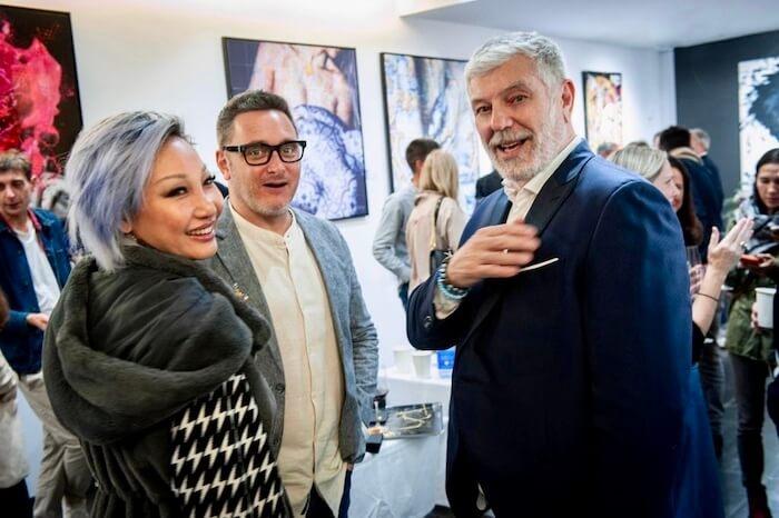 Stephane alaux en train de parler à un homme et une femme pendant les portes ouvertes de sa galerie