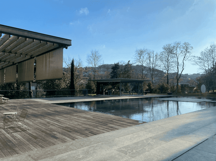 Espace extérieur du centre culturel Hara à Sarıyer, offrant un cadre paisible avec terrasse en bois et bassin, idéal pour des événements artistiques et culturels.
