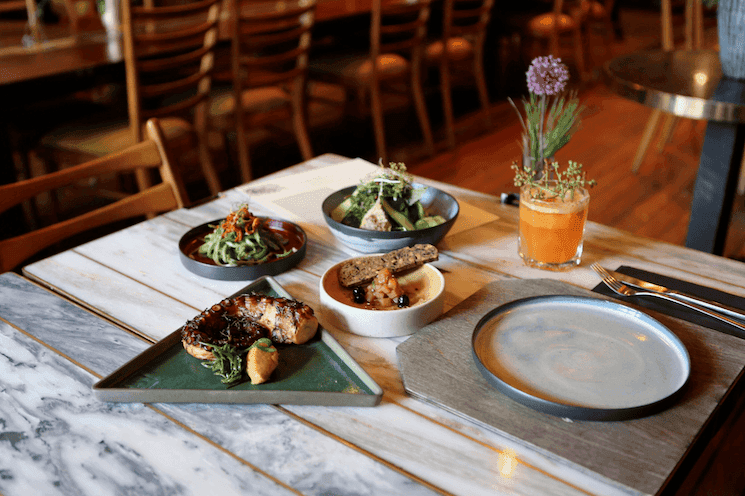 Table élégamment dressée au restaurant Hiç Lokanta à Izmir, présentant des plats biologiques et créatifs dans un cadre chaleureux.