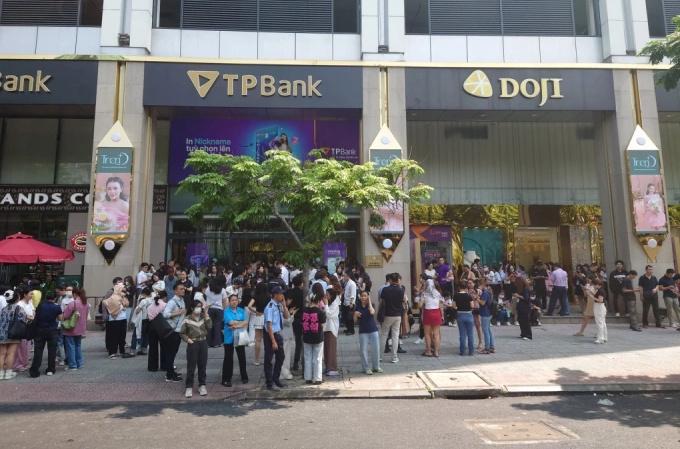 Les gens qui travaillent dans un bâtiment de la rue Ham Nghi dans le district 1 de Hô Chi Minh-Ville se rassemblent sur le sol après avoir senti des tremblements, le 28 mars 2025