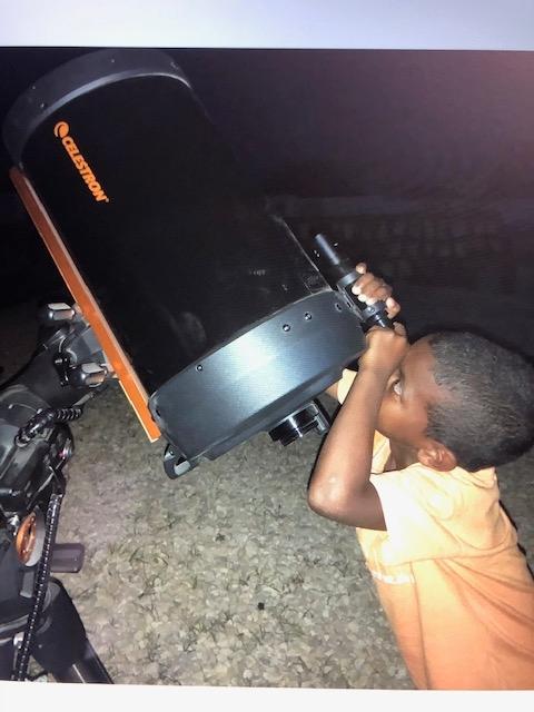 Un élève de L'École du Monde observe le système solaire avec un télescope